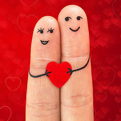 Happy couple in love with painted smiley holding red heart